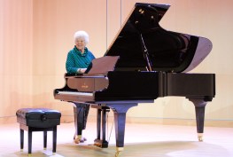 Lila Stewart and the Shigeru Kawai piano that she has given to the Longmont Museum's Stewart Auditotrium